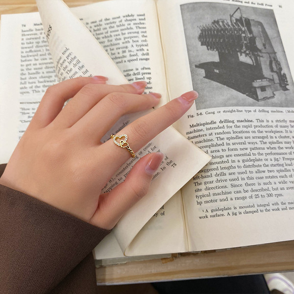 Hétköznapi vékony női gyűrű szívvel és kövekkel