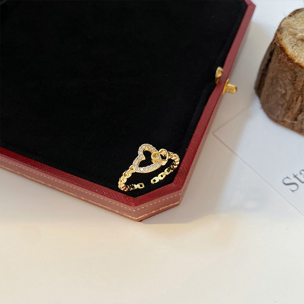 Hétköznapi vékony női gyűrű szívvel és kövekkel