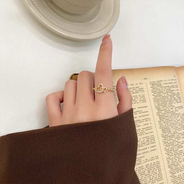 Hétköznapi vékony női gyűrű szívvel és kövekkel