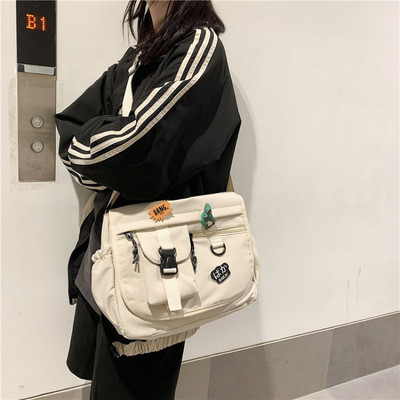 Embleemide ja pika sangaga igapäevane meestekott