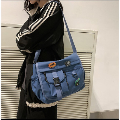 Embleemide ja pika sangaga igapäevane meestekott