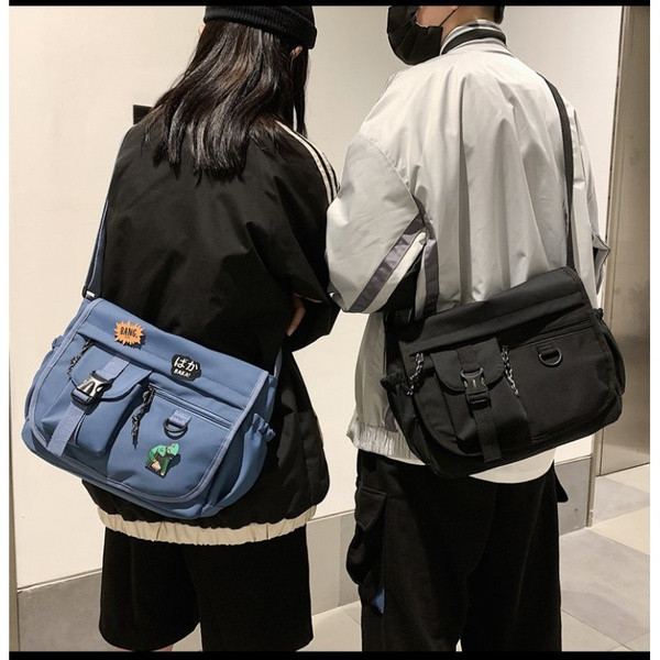 Embleemide ja pika sangaga igapäevane meestekott