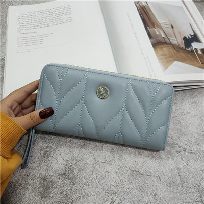 Női bőr pénztárca fém díszítéssel és bőr fogantyúval