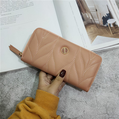 Női bőr pénztárca fém díszítéssel és bőr fogantyúval