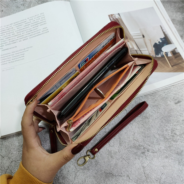 Női bőr pénztárca fém díszítéssel és bőr fogantyúval