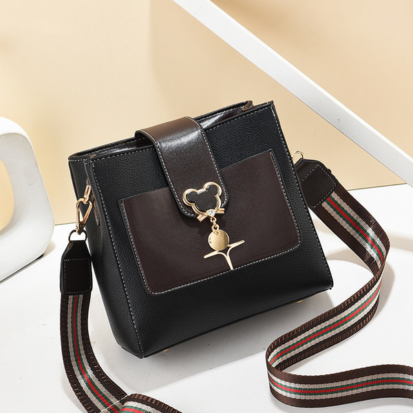 Kis bőrtáska hosszú textil fogantyúval