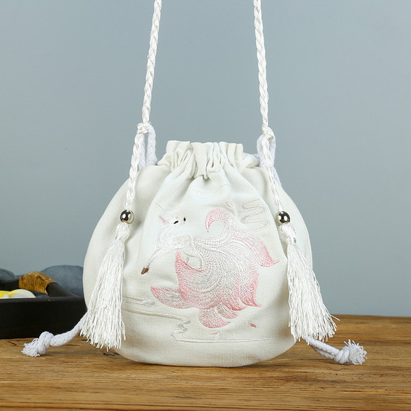 Női textiltáska hímzéssel és bojttal