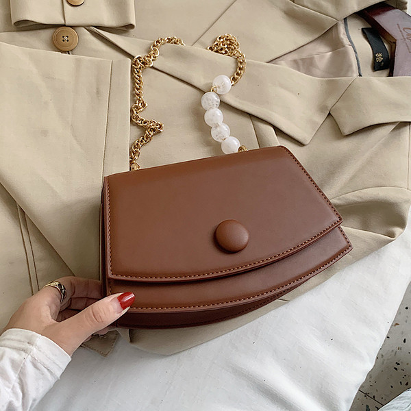 Modern bőrtáska fém fogantyúval és gyöngyökkel