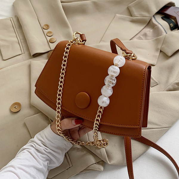 Modern bőrtáska fém fogantyúval és gyöngyökkel