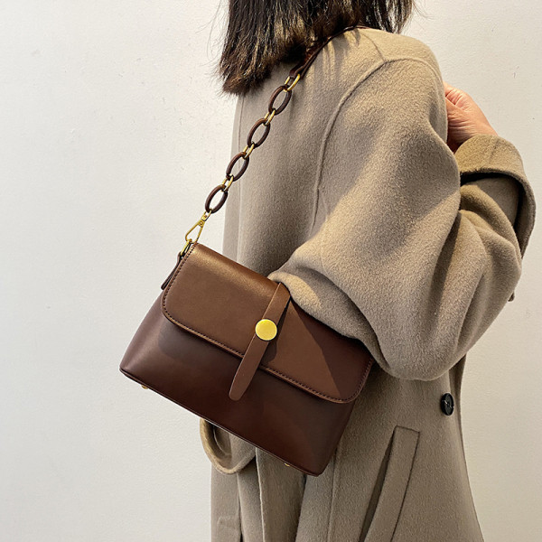 Női bőr táska fém csattal és két fogantyúval