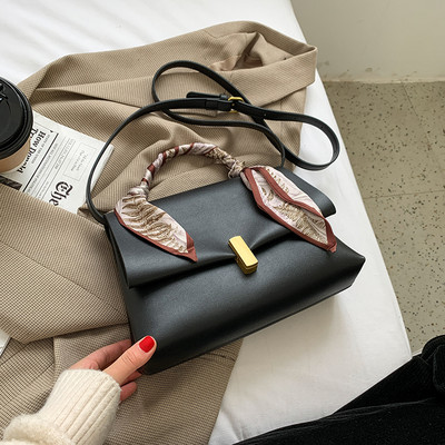 Elegantna ženska torba s metalnom kopčom i vrpcom u boji