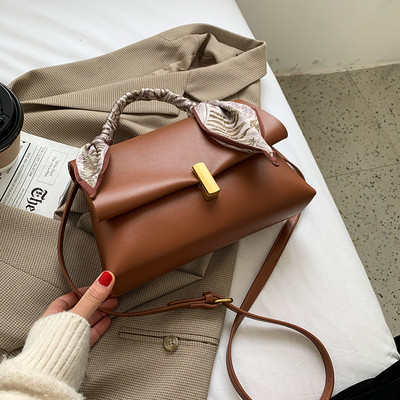 Elegantna ženska torba s metalnom kopčom i vrpcom u boji