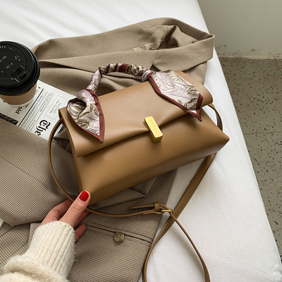 Elegantna ženska torba s metalnom kopčom i vrpcom u boji