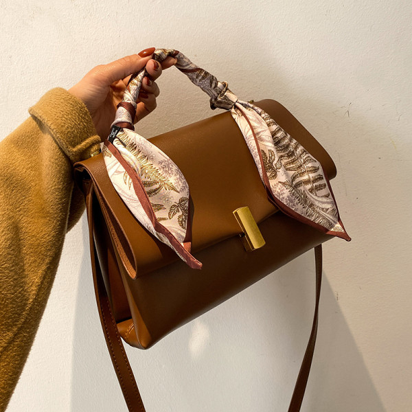 Elegantna ženska torba s metalnom kopčom i vrpcom u boji