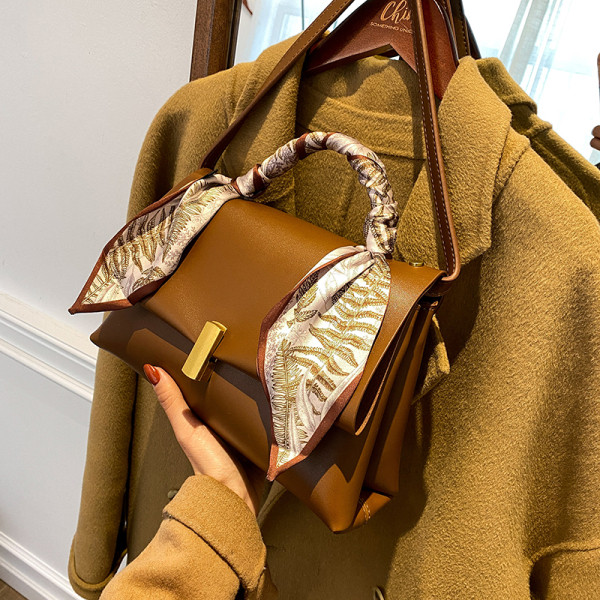 Elegantna ženska torba s metalnom kopčom i vrpcom u boji