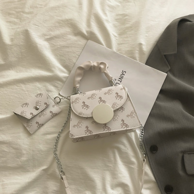 Kis négyzet alakú táska két fogantyúval és nyomattal