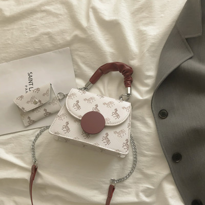 Kis négyzet alakú táska két fogantyúval és nyomattal