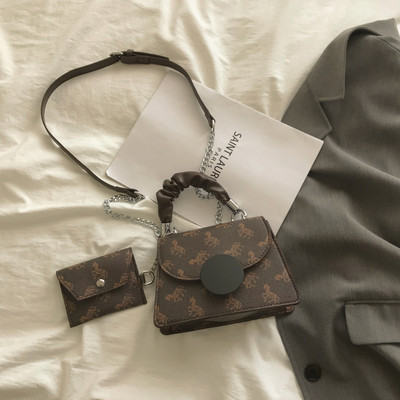 Kis négyzet alakú táska két fogantyúval és nyomattal