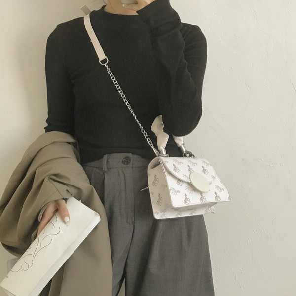 Kis négyzet alakú táska két fogantyúval és nyomattal