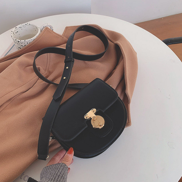 Ženska kožna torba s metalnim kopčanjem i kožnom ručkom