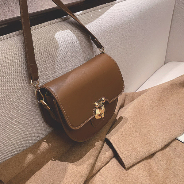 Ženska kožna torba s metalnim kopčanjem i kožnom ručkom