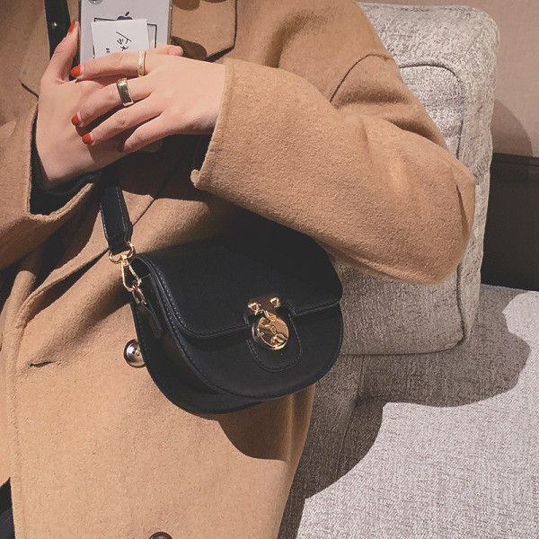 Ženska kožna torba s metalnim kopčanjem i kožnom ručkom