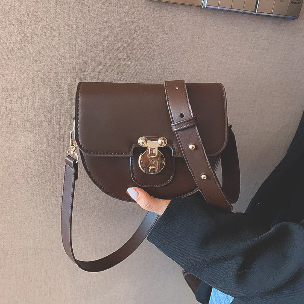 Ženska kožna torba s metalnim kopčanjem i kožnom ručkom