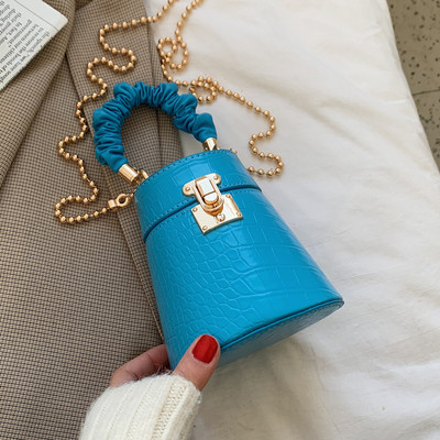 Kis női bőrtáska fém csattal és lánccal