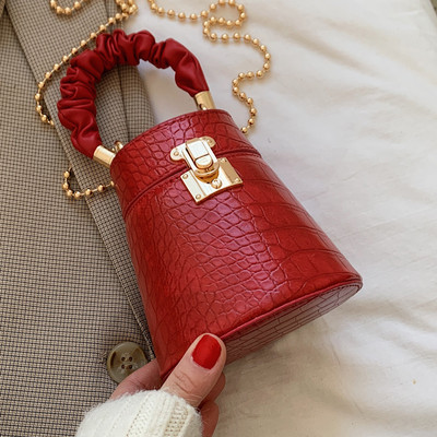 Kis női bőrtáska fém csattal és lánccal