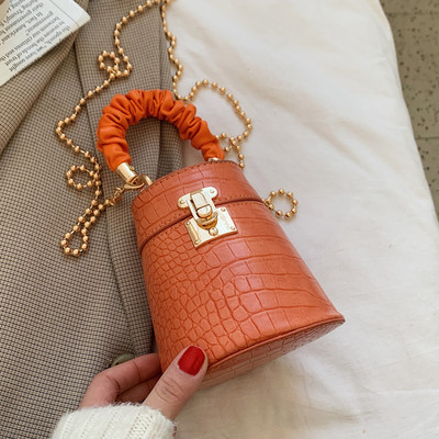 Kis női bőrtáska fém csattal és lánccal