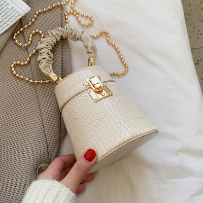 Kis női bőrtáska fém csattal és lánccal