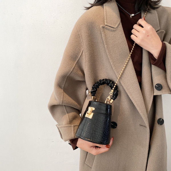 Kis női bőrtáska fém csattal és lánccal