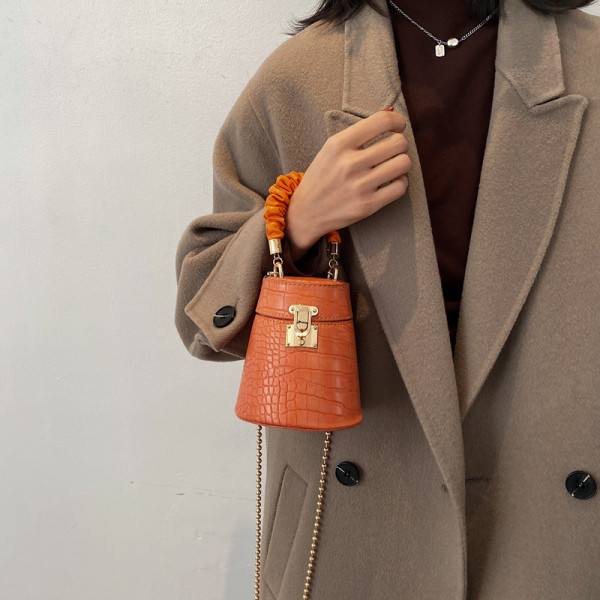 Kis női bőrtáska fém csattal és lánccal