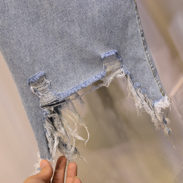 Moodsad naiste asümmeetrilised rebenenud motiividega teksad