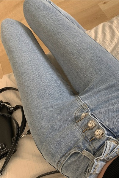 Õhukese mudeli kõrge vöökoha ja nööpidega naiste teksad