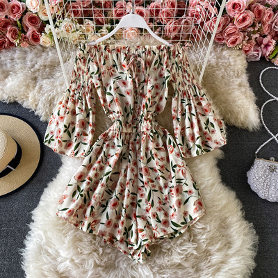 Κοντή γυναικεία ολόσωμη φόρμα με λουλουδάτο μοτίβο και γυμνούς ώμους