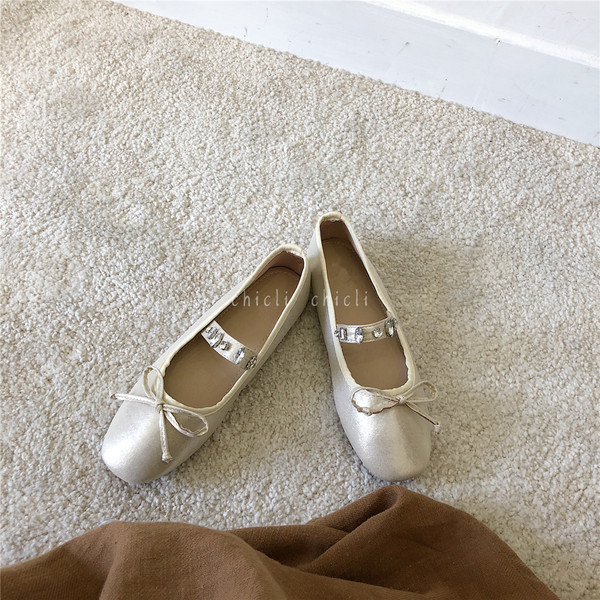 Mūsdienīgi sieviešu apavi ar plakanām zolēm un dekorācijas akmeņiem