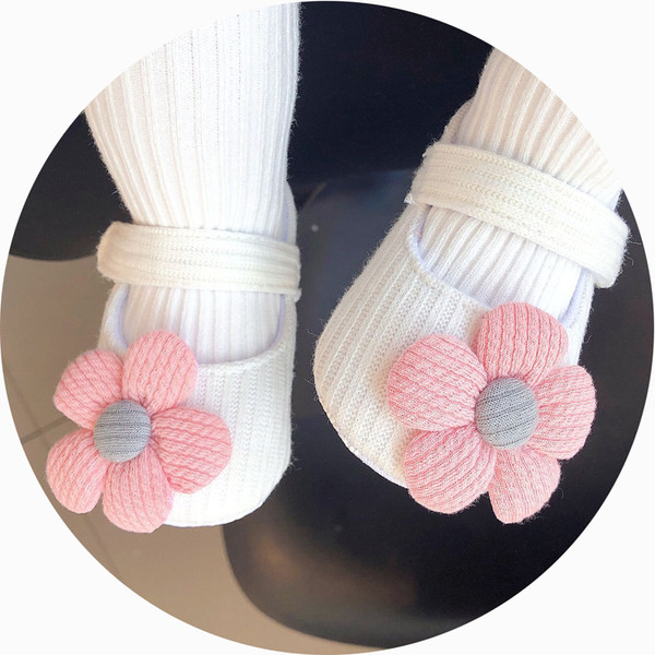 Sandale tricotate pentru bebeluși pentru o fată cu o floare