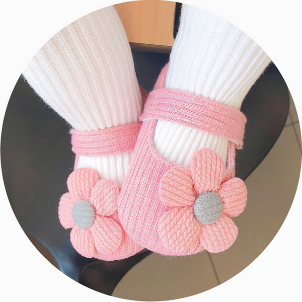 Sandale tricotate pentru bebeluși pentru o fată cu o floare