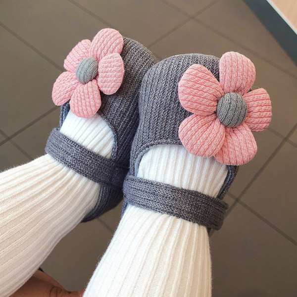 Sandale tricotate pentru bebeluși pentru o fată cu o floare