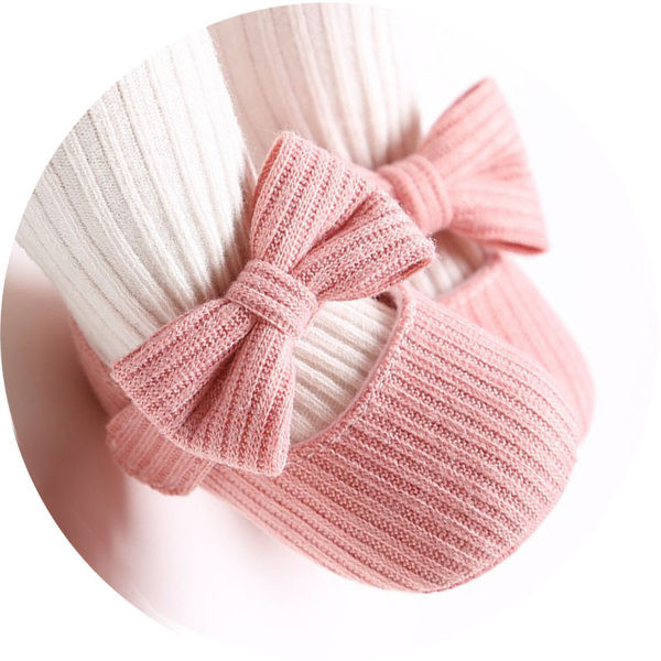 Sandale tricotate pentru bebeluși pentru o fată cu o floare