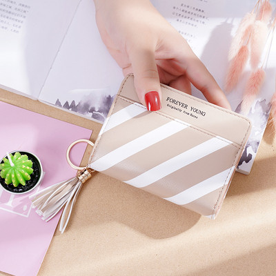 Μικρό γυναικείο πορτοφόλι με μεταλλικό μενταγιόν και φούντα