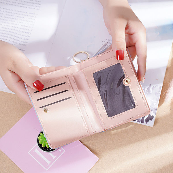 Μικρό γυναικείο πορτοφόλι με μεταλλικό μενταγιόν και φούντα