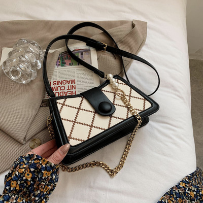 Γυναικεία τσάντα με μεταλλικό κούμπωμα και μακριά μεταλλική λαβή με πέρλες