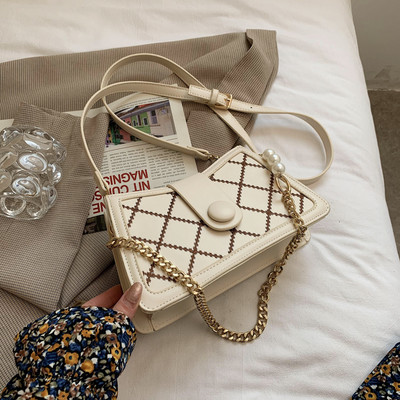 Γυναικεία τσάντα με μεταλλικό κούμπωμα και μακριά μεταλλική λαβή με πέρλες