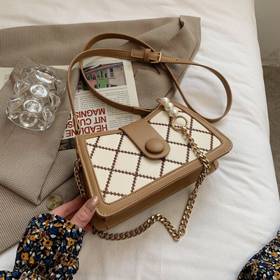 Γυναικεία τσάντα με μεταλλικό κούμπωμα και μακριά μεταλλική λαβή με πέρλες