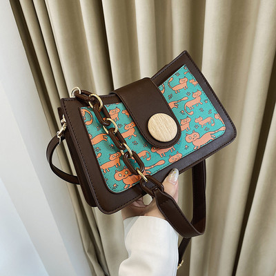 Sieviešu kvadrātveida soma ar aplikāciju un garu rokturi