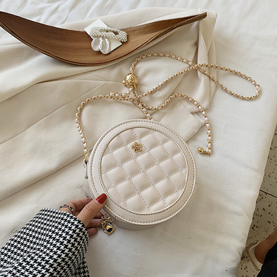 Γυναικεία στρογγυλή τσάντα με μεταλλική διακόσμηση