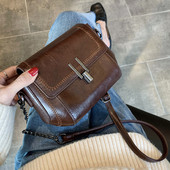 Ādas soma ar metāla aizdari un garu rokturi