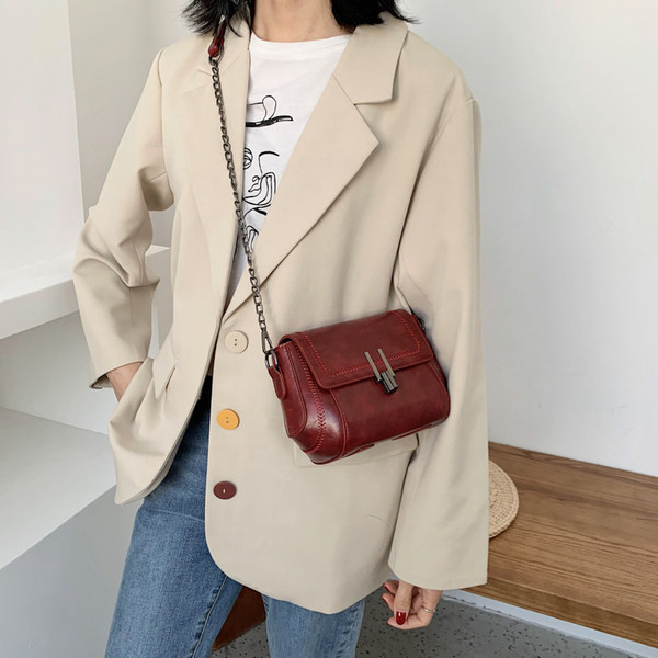 Ādas soma ar metāla aizdari un garu rokturi